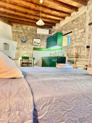 a large bed in a kitchen with green cabinets at Cornaro House in Arsos