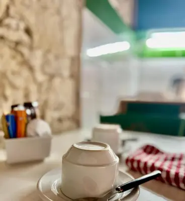 a cup of coffee on a table with a spoon at Cornaro House in Arsos