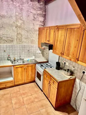 a kitchen with wooden cabinets and a stove top oven at Cornaro House in Arsos