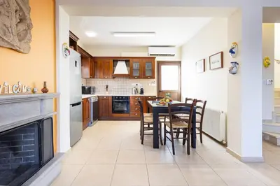 a kitchen and dining room with a table and chairs at Villa Joan in Ayios Theodhoros