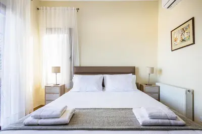 a bedroom with a white bed with two towels on it at Villa Joan in Ayios Theodhoros