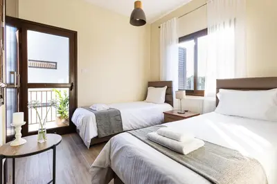 a bedroom with two beds and a window at Villa Joan in Ayios Theodhoros