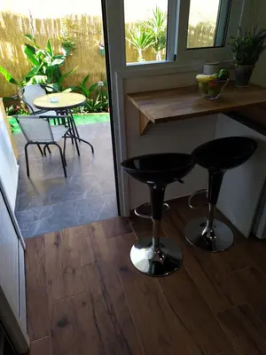 a kitchen with two black stools and a table at Takis apartments in Ayia Napa