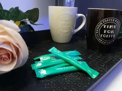 a table with a cup of coffee and some green wrappers at Takis apartments in Ayia Napa