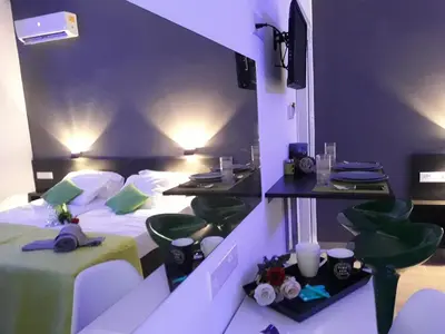 a hotel room with two beds and two tables at Takis apartments in Ayia Napa