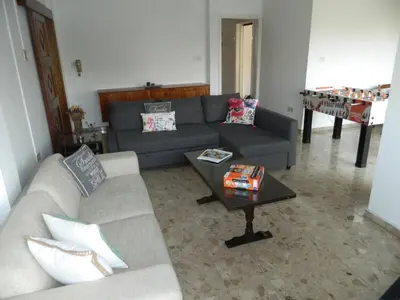 a living room with a couch and a table at Family Nest In The Heart Of Limassol in Limassol