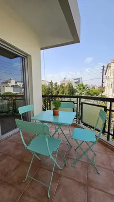 a patio with a table and chairs on a balcony at Family Nest In The Heart Of Limassol in Limassol