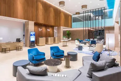 a lobby with blue chairs and tables in a building at Radisson Blu Hotel, Larnaca in Larnaka