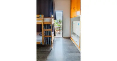 a room with a bunk bed and a hallway at House of Nissus Hostel in Ayia Napa