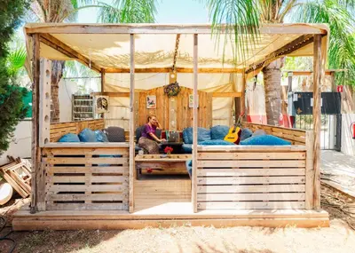 a man sitting in a bed in a tent at House of Nissus Hostel in Ayia Napa