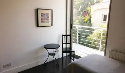 a bedroom with a chair next to a window at The Kapitani Residence in Nicosia
