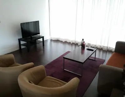 a living room with two chairs and a table and a television at The Kapitani Residence in Nicosia