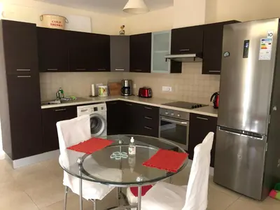 a kitchen with a glass table and a stainless steel refrigerator at Tranquil Country Condo - Tersefanou in Larnaka