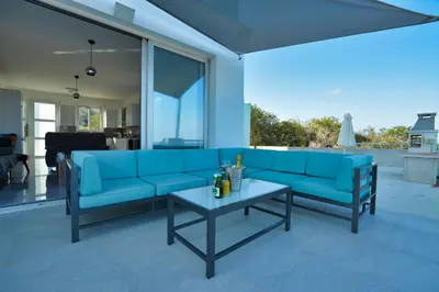 a living room with a blue couch and a table at Aetopetra Villa in Protaras