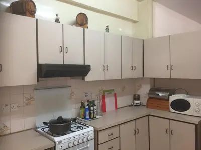 a kitchen with white cabinets and a stove top oven at Artemis House in Limassol