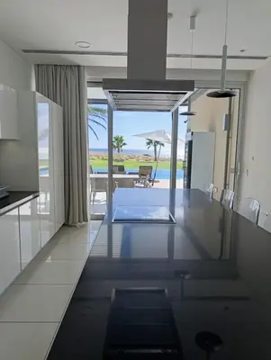 a kitchen and dining room with a view of the beach at Beachfront Luxury Villa Glory in Ayia Napa