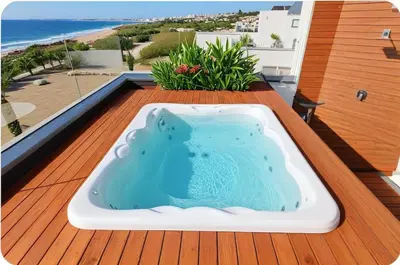 a hot tub on a deck with a view of the beach at Beachfront Luxury Villa Glory in Ayia Napa