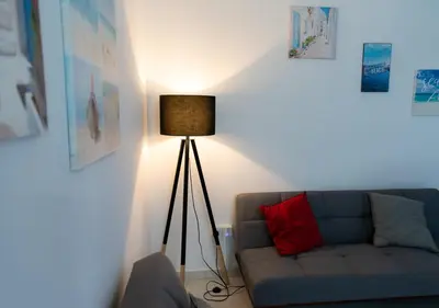 a living room with a blue couch and a lamp at Kypkeys Apartments in Voroklini