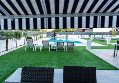a patio with chairs and a table and a pool at Kypkeys Apartments in Voroklini