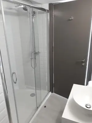a shower with a glass door next to a sink at Protaras Plaza Hotel in Protaras