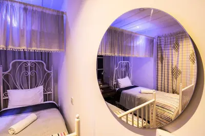a purple room with two beds and a mirror at Anastou's Traditional House in Kalopanayiotis