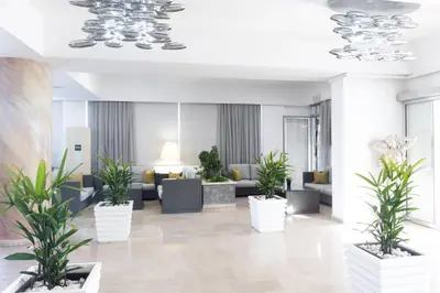 a lobby with potted plants and couches at Vrissaki Hotel Apartments in Protaras