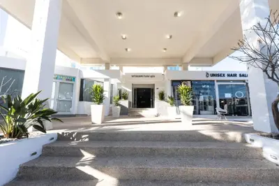 a view of a building with plants in front of it at Vrissaki Hotel Apartments in Protaras