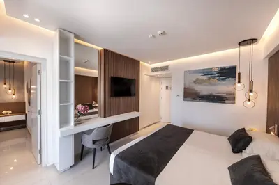 a bedroom with a bed and a desk in it at Pavlo Napa Beach Hotel in Ayia Napa