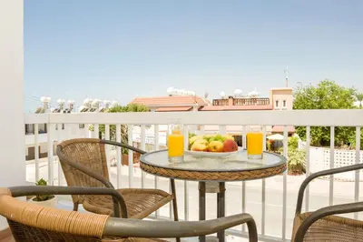 a table with a bowl of fruit on a balcony at MyNapa Apartments in Ayia Napa