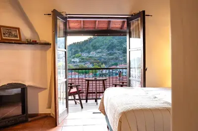 a bedroom with a door open to a balcony with a table at Ambelikos Traditional Agrohotel in Potamitissa
