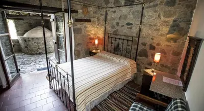 a bedroom with a swinging bed in a stone wall at Ambelikos Traditional Agrohotel in Potamitissa