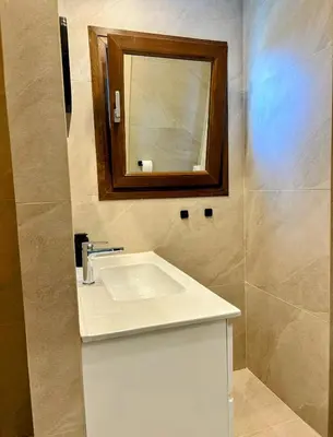 a bathroom with a white sink and a mirror at Pigeon Beach Hotel Apartments in Limassol