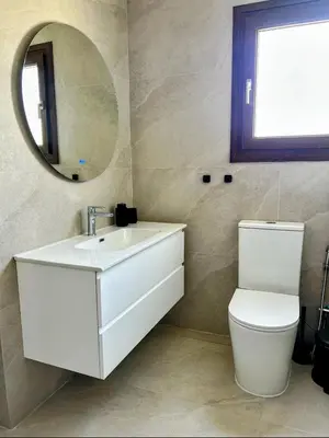 a bathroom with a sink and a toilet and a mirror at Pigeon Beach Hotel Apartments in Limassol