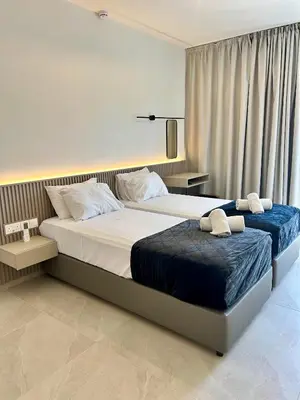 a bedroom with two beds and a window at Pigeon Beach Hotel Apartments in Limassol