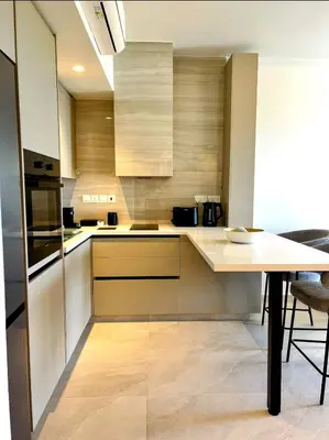 a kitchen with wooden cabinets and a wooden table at Pigeon Beach Hotel Apartments in Limassol