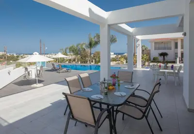 a patio with a table and chairs and a pool at Villa Gardenia in Protaras