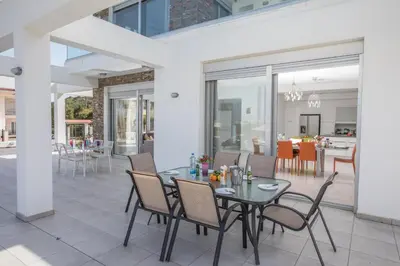 a dining room with a table and chairs on a patio at Villa Gardenia in Protaras