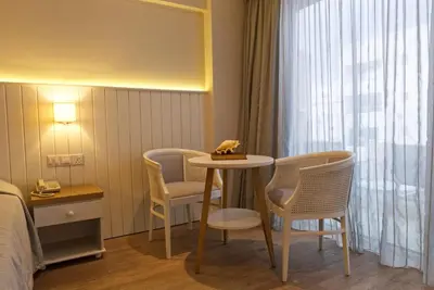 a hotel room with a table and chairs and a bed at Sunrise Gardens Aparthotel in Protaras