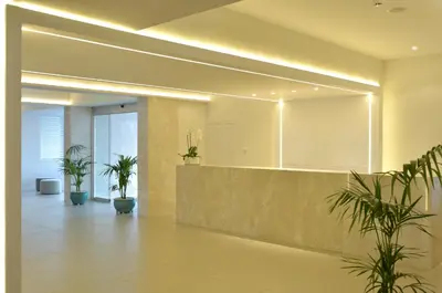 a lobby with potted plants and a large mirror at Sunrise Gardens Aparthotel in Protaras