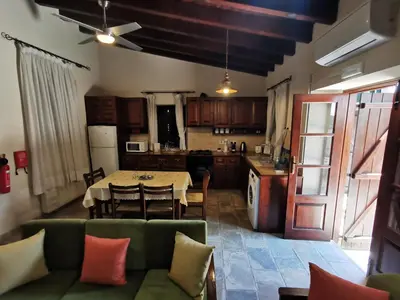 a kitchen with a green couch and a table with chairs at Stou Kir Yianni in Omodos