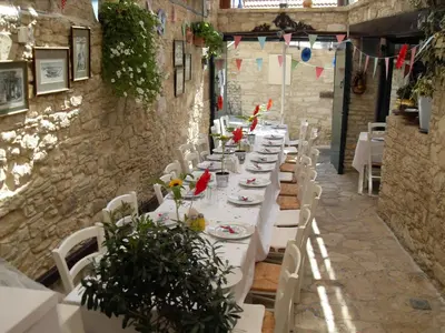 a long table with white tables and white chairs at Stou Kir Yianni in Omodos
