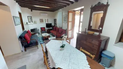 a living room with a table and a living room with red chairs at Stou Kir Yianni in Omodos
