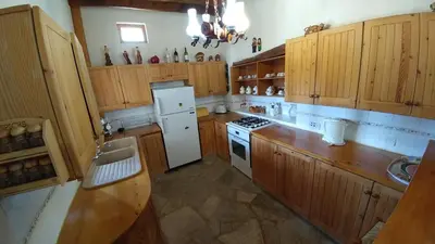 a kitchen with wooden cabinets and a white refrigerator at Stou Kir Yianni in Omodos