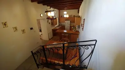 a room with a staircase with a kitchen and a stair railing at Stou Kir Yianni in Omodos