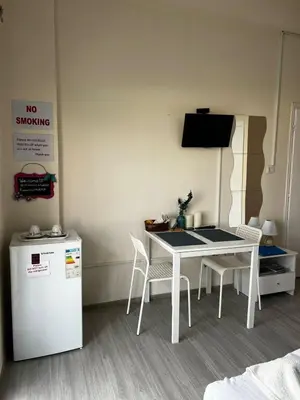 a kitchen with a white table and chairs and a refrigerator at Lucky 5 in Paralimni