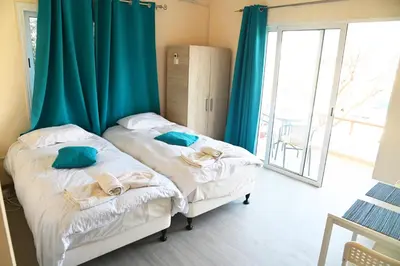 two beds in a room with blue curtains at Lucky 5 in Paralimni