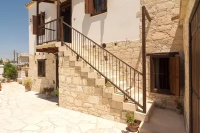 a stone building with stairs on the side of it at Olympia Traditional Houses in Lymbia