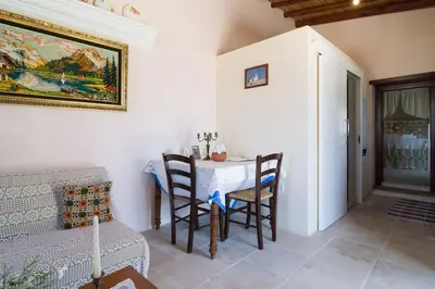 a dining room with a table and chairs in a room at Olympia Traditional Houses in Lymbia