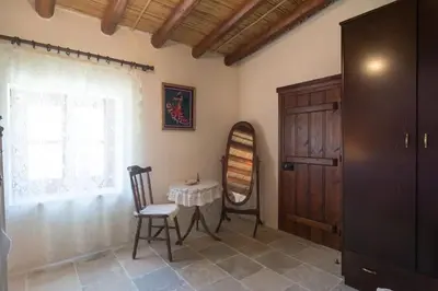 a room with a table and a chair and a window at Olympia Traditional Houses in Lymbia