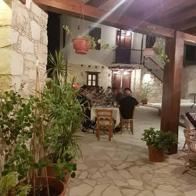 a group of people sitting at a table in a restaurant at Olympia Traditional Houses in Lymbia